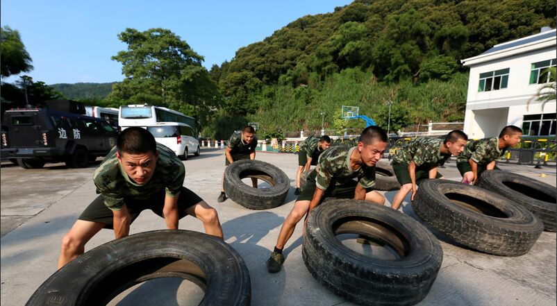官兵们正在拉动卡车轮胎