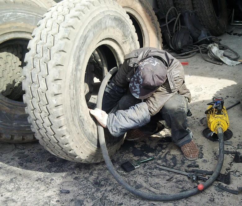 司机在修理铺修车时.轮胎意外突爆造成修理工死亡.是负责